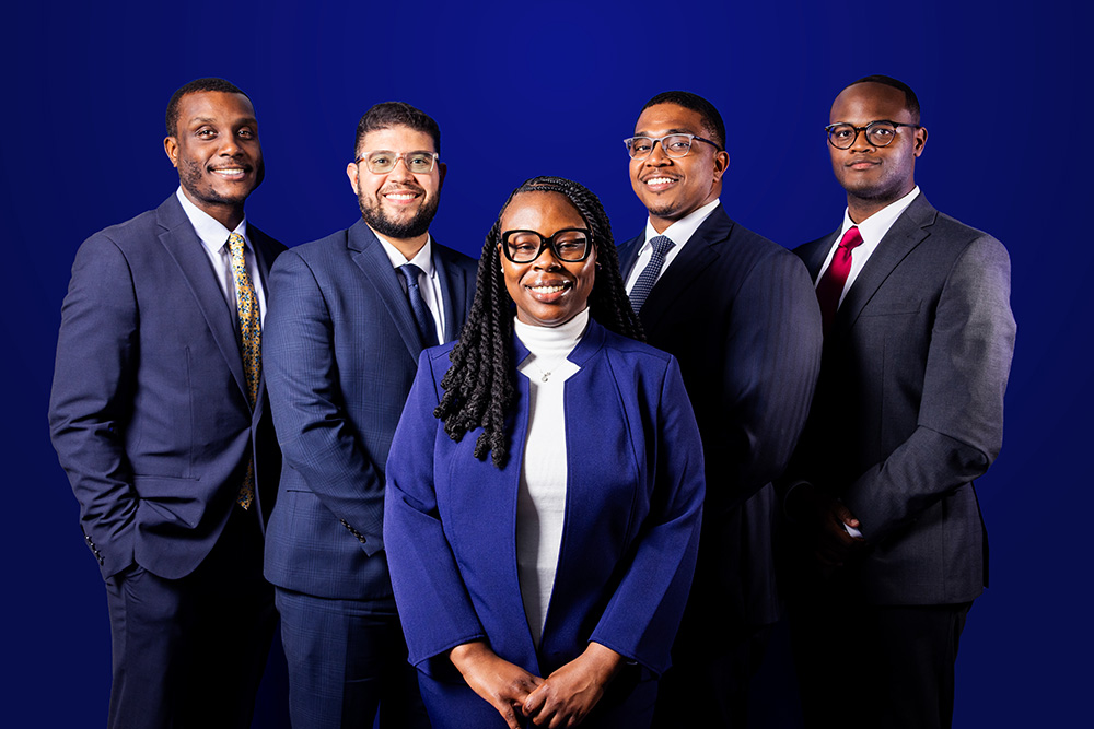 Nubian Square Investment Advisors leadership team posed in front of a blue background, symbolizing expertise, culture, and financial navigation.