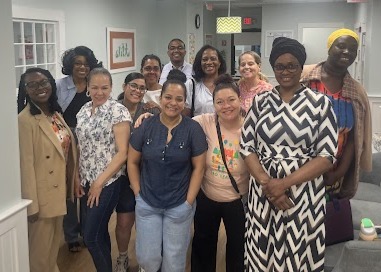 A group of 10 early childhood educators and 2 financial professionals standing and smiling at the camera