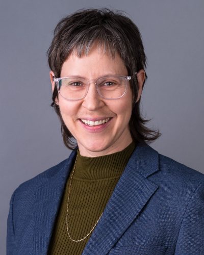 Mac Headshot Nov 2025 - Web crop olive